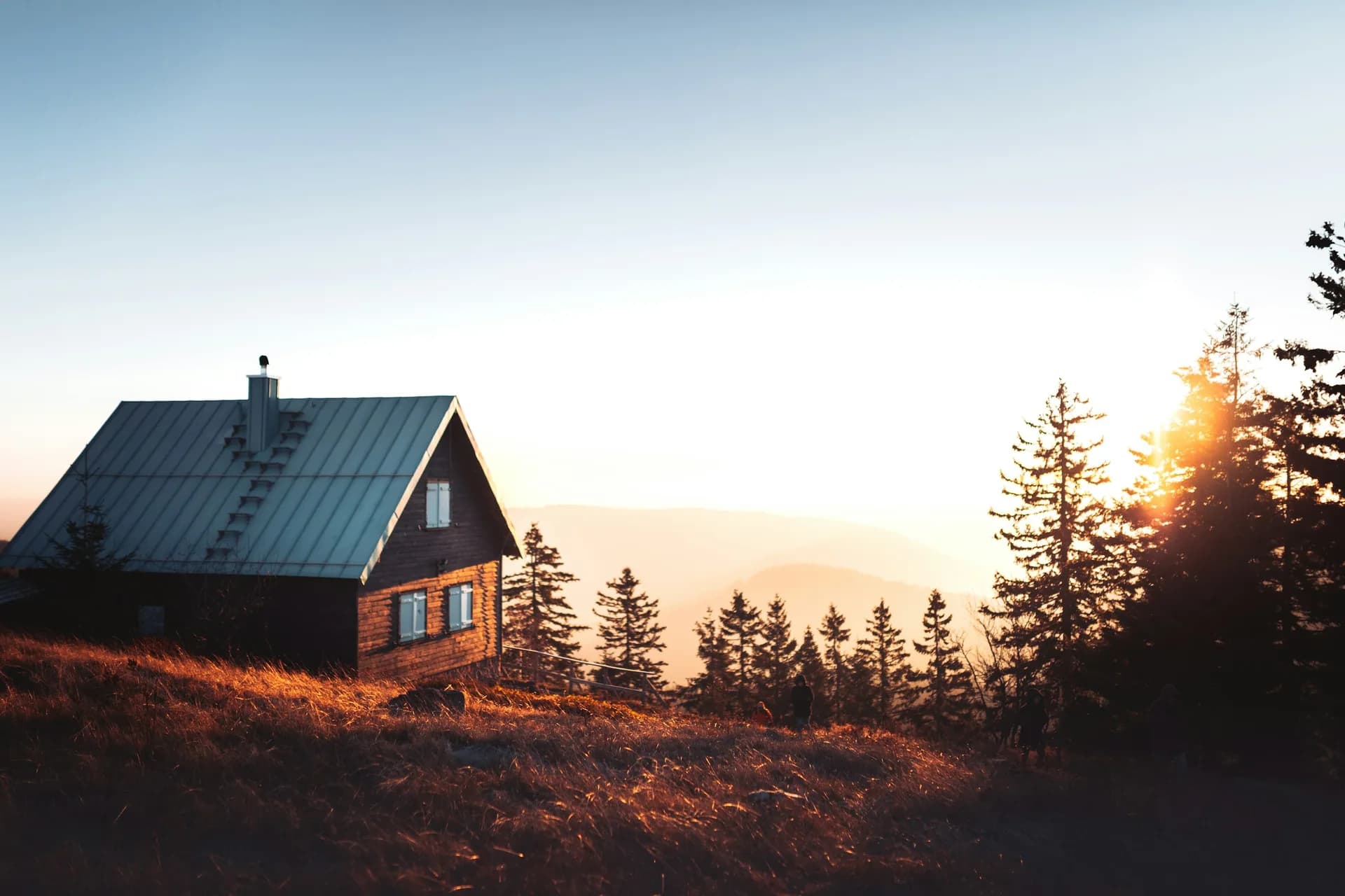 Standing seam metal roof catching the last light off a Hill Country ridge