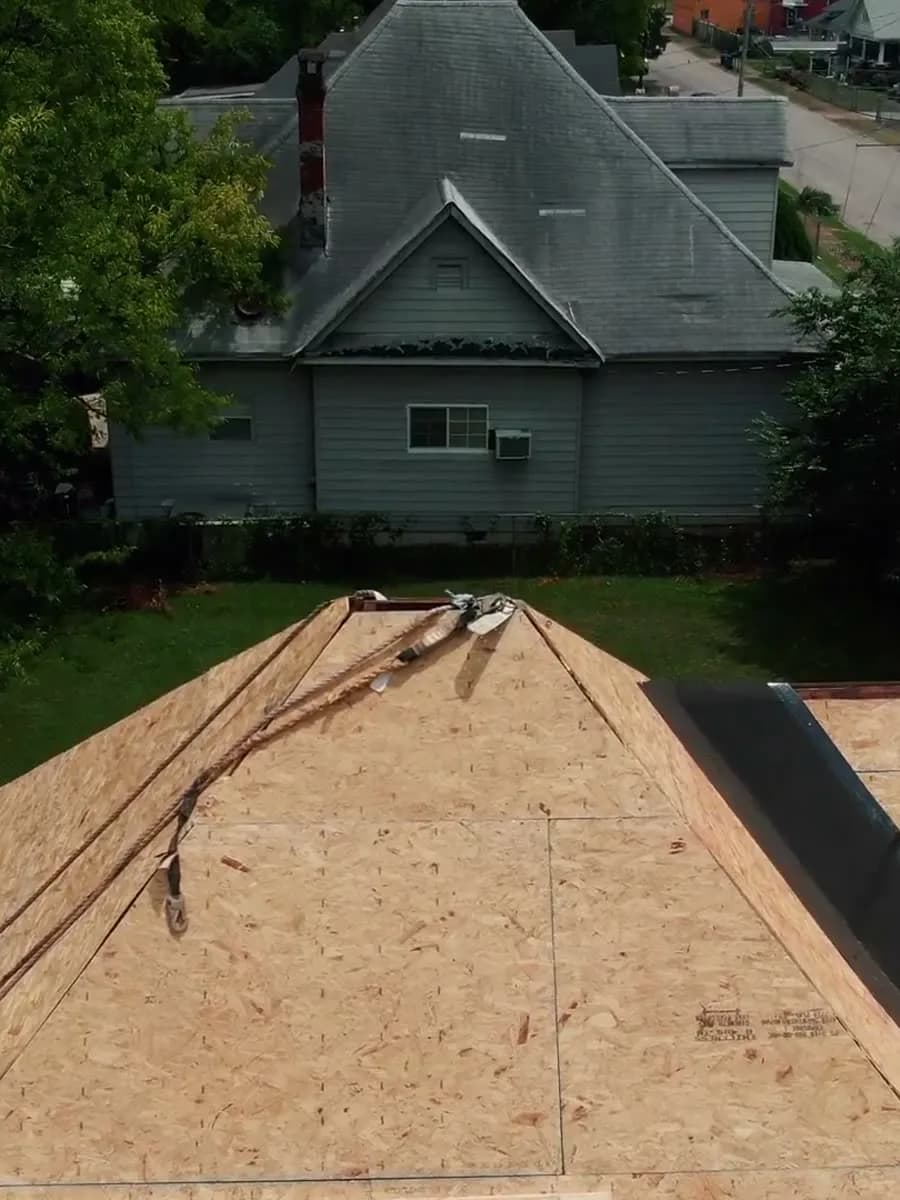 Tear-off underway on a two-story home, decking exposed