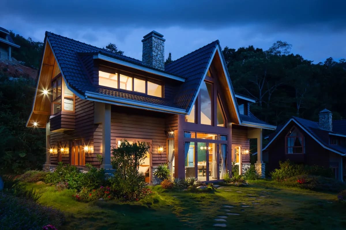 Craftsman home lit at night under a finished tile roof