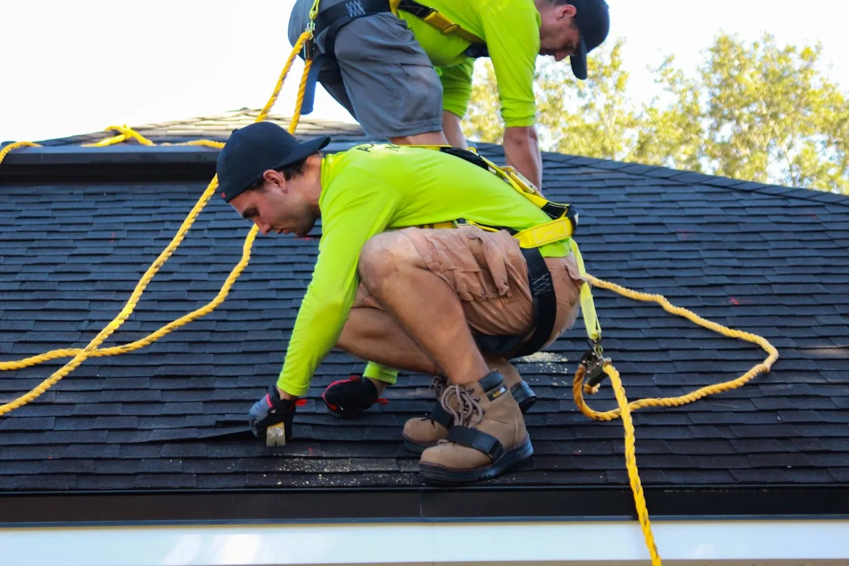 Crew running architectural shingles up a steep pitch