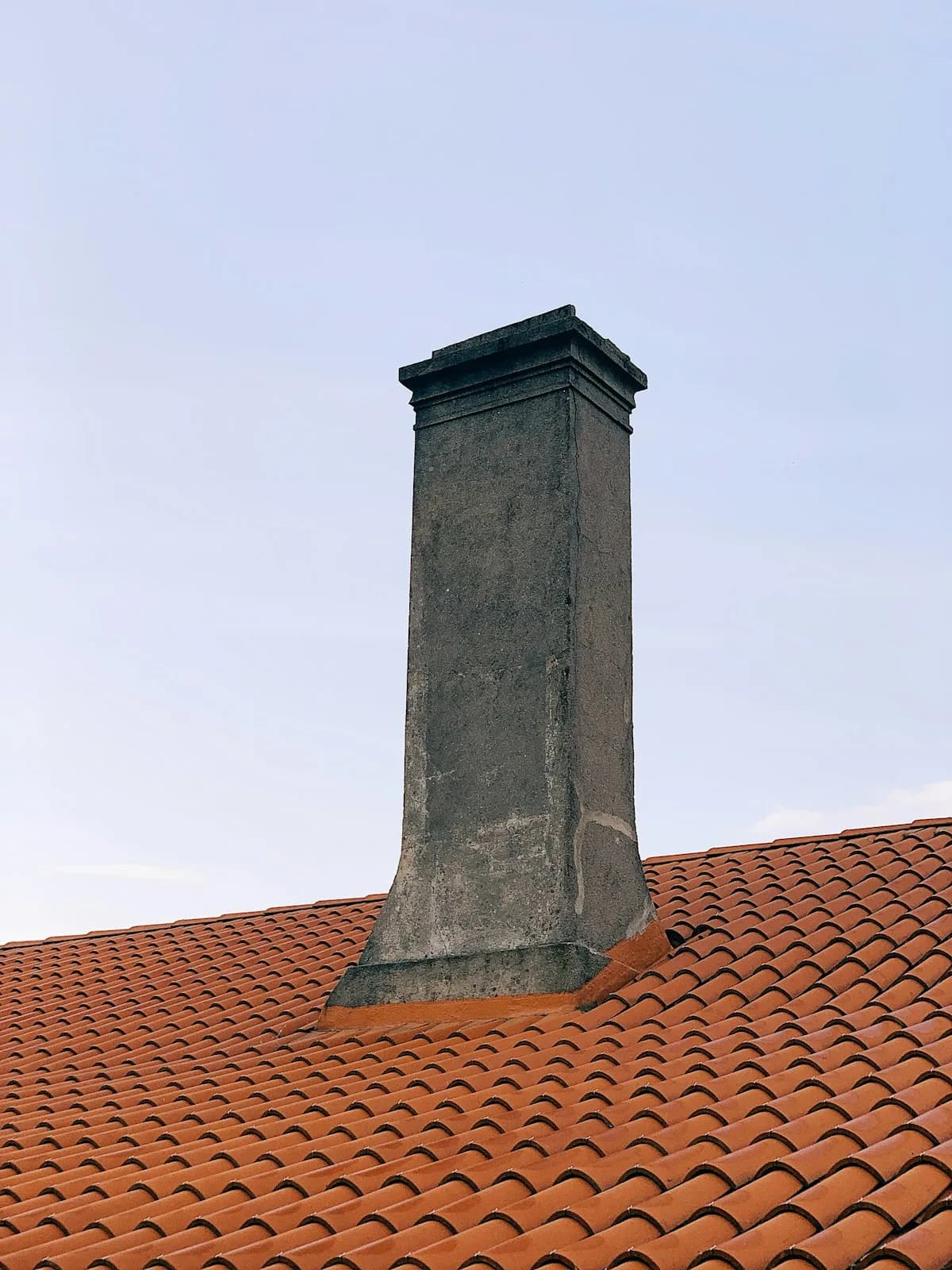 A rebuilt chimney crown on a terracotta roof